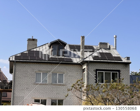 Brick House With Solar Panels on Sunny Day 130558068