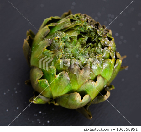 cooked artichokes on black stone board cooked artichokes on black stone board 130558951