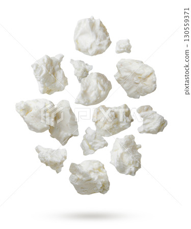 Pieces of cottage cheese flying on a white background. Isolated 130559371