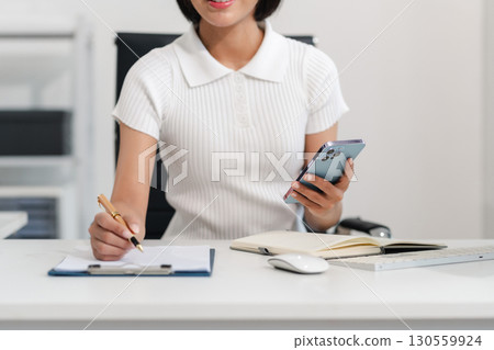 Businesswoman analyzing financial graphs, calculating company expenses, and planning investments, corporate, accounting, and economic strategy. 130559924