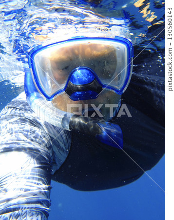 Snorkeling activity in Red sea Egypt with person wearing diving mask and snorkel swimming near water Snorkeling activity in Red sea Egypt with person wearing diving mask and snorkel swimming near water 130560143
