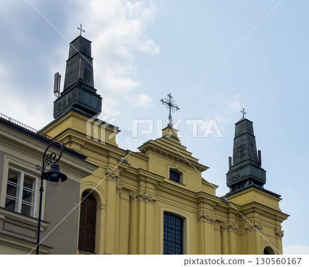 Baroque Church of the Holy Cross in Warsaw, Poland with a yellow ornamental facade, twin towers 130560167