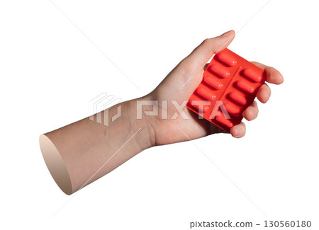 Close up of hand holding red medical blister. Idea of healthcare, drugs, and prescription treatment 130560180