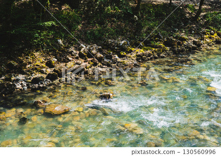 Rocky, mossy bank of a fast mountain stream on a sunny summer day Rocky, mossy bank of a fast mountain stream on a sunny summer day 130560996