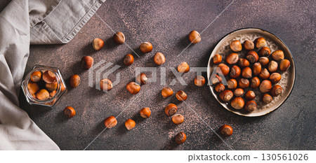 Nutritious hazelnuts on a plate and in a jar on the table top view web banner Nutritious hazelnuts on a plate and in a jar on the table top view web banner 130561026