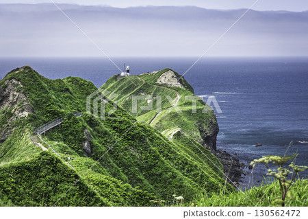 延伸至海角的山脊線、白色燈塔與藍色大海的對比 130562472