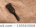 Hair loss concept with hairbrush on soft beige background 130563008