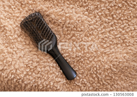 Hair loss concept with hairbrush on soft beige background 130563008