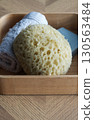 Dermo Aqua soft bath sponge on a wooden background 130563484