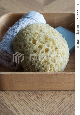 Dermo Aqua soft bath sponge on a wooden background Dermo Aqua soft bath sponge on a wooden background 130563484
