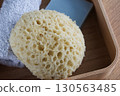 Dermo Aqua soft bath sponge on a wooden background 130563485