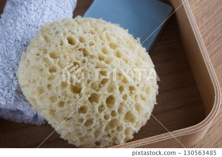 Dermo Aqua soft bath sponge on a wooden background Dermo Aqua soft bath sponge on a wooden background 130563485