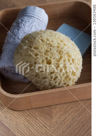 Dermo Aqua soft bath sponge on a wooden background Dermo Aqua soft bath sponge on a wooden background 130563486
