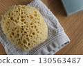 Dermo Aqua soft bath sponge on a wooden background 130563487