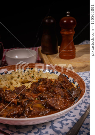 Hungarian goulash with spaetzle: savory beef stew and egg noodles dish 130563891