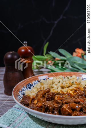 Delicious hungarian goulash with spaetzle on rustic table setting 130563901