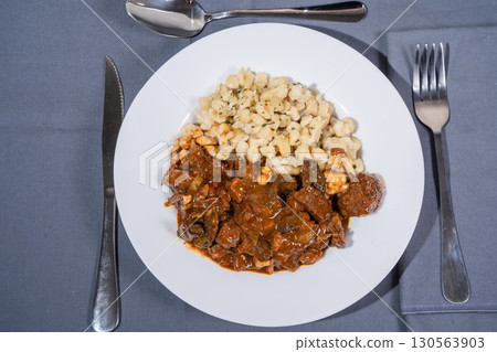 Delicious hungarian goulash with spaetzle on white plate 130563903