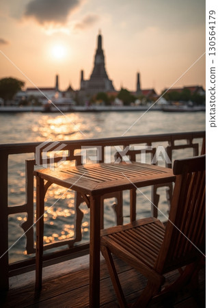 Wooden table balcony view of Wat Arun temple by Chao Phraya River at sunset Bangkok Wooden table balcony view of Wat Arun temple by Chao Phraya River at sunset Bangkok 130564179