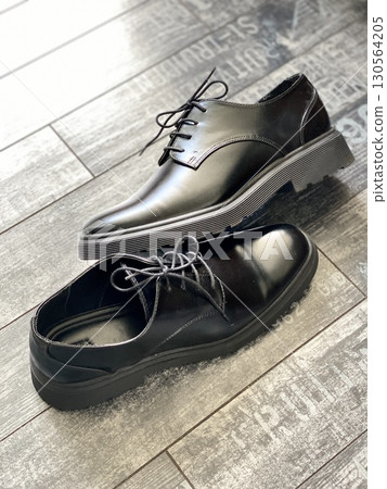Black leather dress shoes on wooden floor with textured background Black leather dress shoes on wooden floor with textured background 130564205