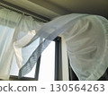 Lace curtains and windows swaying in the wind 130564263