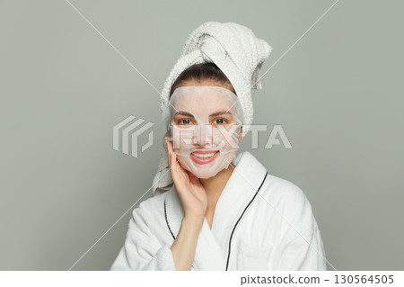 Happy young woman with moisturizing, rejuvenating white fabric sheet mask from her face Happy young woman with moisturizing, rejuvenating white fabric sheet mask from her face 130564505