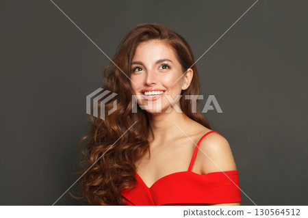 Lovely woman with long hair and make-up on black background. Gorgeous woman with curly hairstyle Lovely woman with long hair and make-up on black background. Gorgeous woman with curly hairstyle 130564512