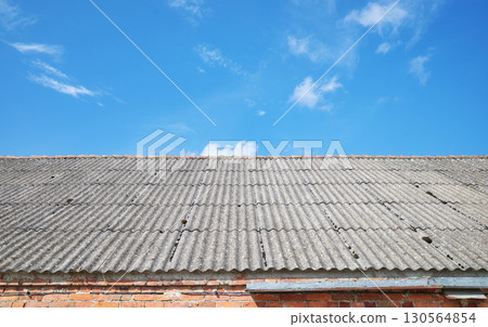 Photo of a roof made of carcinogenic asbestos tiles. 130564854