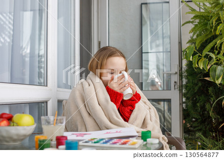 Cute young child relaxing and drinking tea or coffee after painting Cute young child relaxing and drinking tea or coffee after painting 130564877