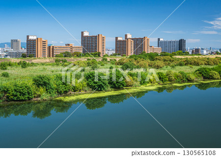 Apartment buildings on the right bank of the Yodo River as seen from Sugawara Johoku Bridge, Osaka City 130565108
