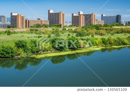Apartment buildings on the right bank of the Yodo River as seen from Sugawara Johoku Bridge, Osaka City 130565109