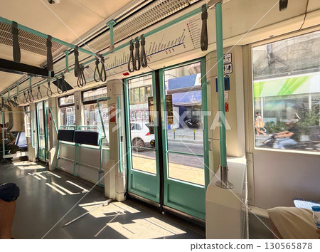Tram doors and seating area in sunlight. Urban commuting, modern infrastructure, and daily travel. 130565878