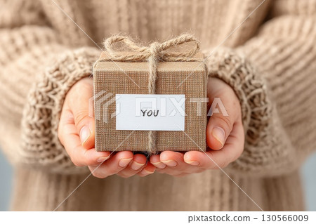 Elegant Wrapped Box Holding with Cozy Knit Sweater Background and Simple You Tag 130566009