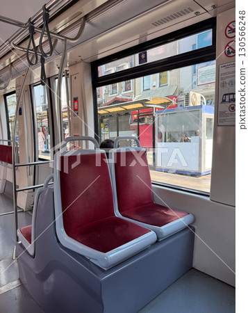 Tram seats by window in public transport. Urban mobility, daily commute, and passenger lifestyle symbolizing infrastructure, travel service, and city connection. 130566248