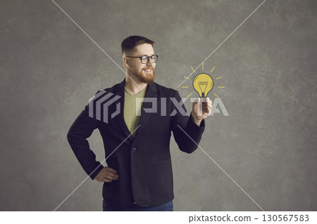 Man holds a painted yellow light bulb in his hand, which symbolizes a wonderful idea. Man holds a painted yellow light bulb in his hand, which symbolizes a wonderful idea. 130567583