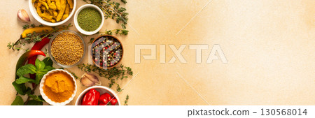 A warm display of spices and herbs on a beige background, each adding rich aromas and flavors, perfect for enhancing recipes, banner 130568014