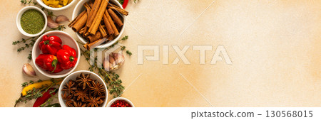 A warm display of spices and herbs on a beige background, each adding rich aromas and flavors, perfect for enhancing recipes, banner 130568015