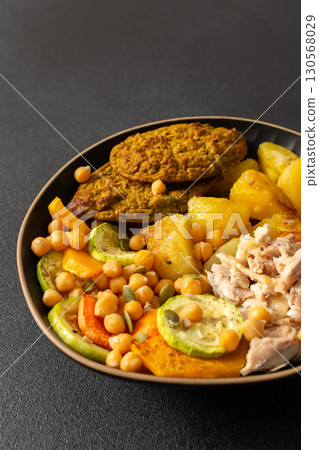 A hearty breakfast features baked sweet potato with carrots and zucchini, chicken breast, lentil cutlets, and kiwi for dessert perfect for a nutritious start A hearty breakfast features baked sweet potato with carrots and zucchini, chicken breast, lentil cutlets, and kiwi for dessert perfect for a nutritious start 130568029