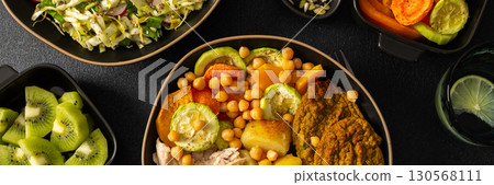 Enjoy a nutritious breakfast with baked sweet potato, carrots, zucchini, chicken breast, and lentil cutlets, complemented by a fresh salad and kiwi for dessert, banner 130568111