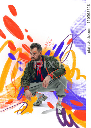 Creative artwork. Male model crouching in casual streetwear with colorful graffiti inspired background Creative artwork. Male model crouching in casual streetwear with colorful graffiti inspired background 130568828