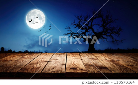 An eerie Halloween night with a silhouette of trees against an orange sky and a full moon An eerie Halloween night with a silhouette of trees against an orange sky and a full moon 130570164