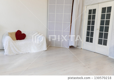 sofa with pillows in the interior of an white room with a door 130570218