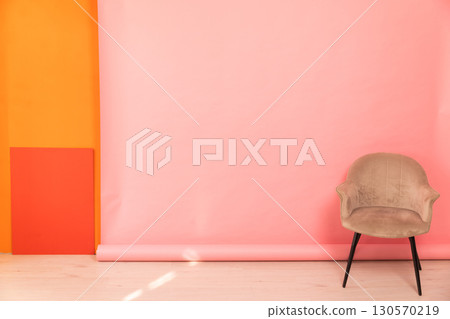 chair in the interior of an empty pink orange room chair in the interior of an empty pink orange room 130570219