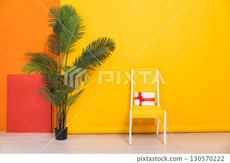 chair with gift in the interior of a yellow orange room 130570222