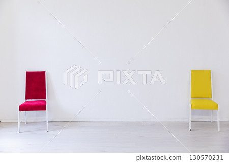 Red and yellow chair in the interior of an white room 130570231