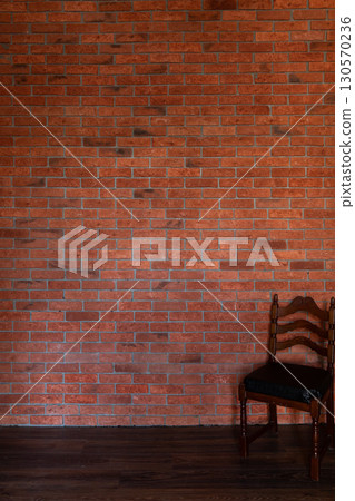 chair in the interior of an empty room with a brick wall 130570236