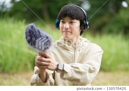 Young man making field recordings Young man making field recordings 130570420
