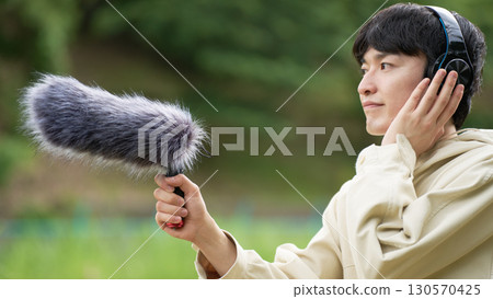 Young man making field recordings Young man making field recordings 130570425