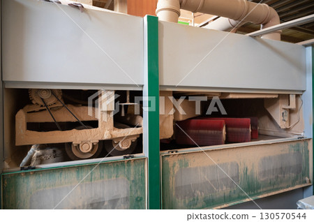 Grinding of wooden furniture panels on a machine 130570544