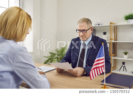 Young woman meeting with USA Consul on question of visa application and immigration 130570552