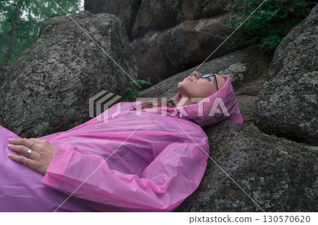 Woman in the taiga forest and rocks of the Stolby nature reserve park 130570620